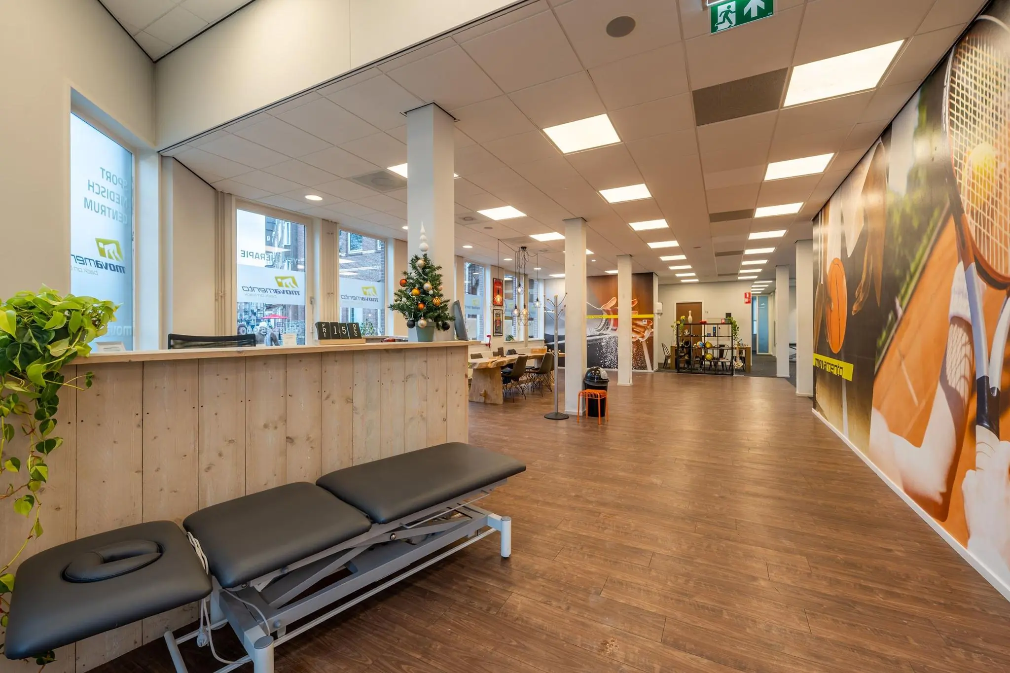 Moderne wachtruimte van het MoveWell sportmedisch centrum aan de Admiraal de Ruijterweg met een behandelbank en speelse wanddecoratie.